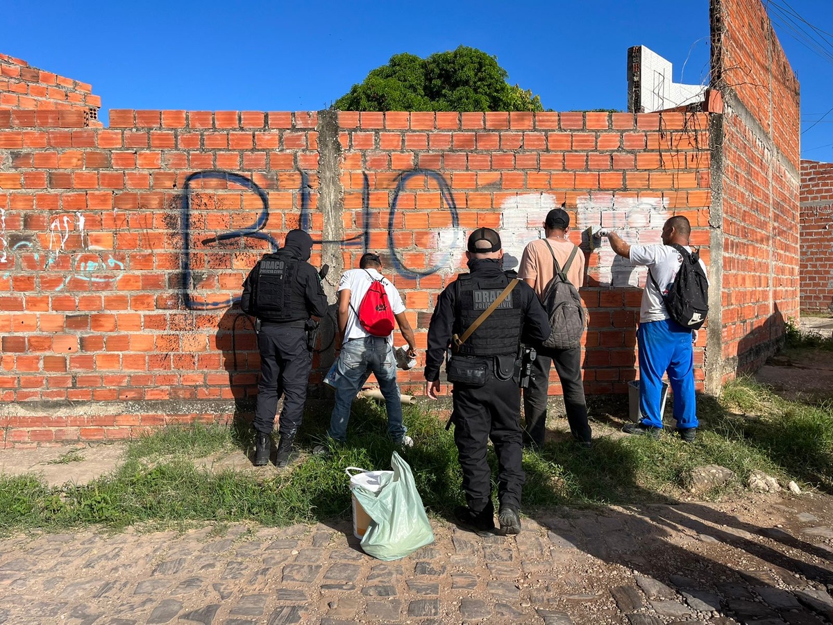 Policiais na árdua tarefa de borrar muros apagando as estripulias da turma de criminosos que dá de goleada no aparelho do Estado