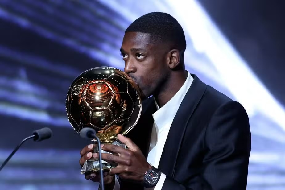 O atacante francês Ousmane Dembélé, do Paris Saint-Germain, beija a Bola de Ouro durante a cerimônia de premiação da Bola de Ouro France Football de 2025, no Théâtre du Chatelet, em Paris