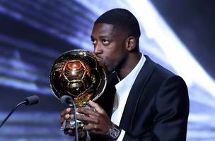 O atacante francês Ousmane Dembélé, do Paris Saint-Germain, beija a Bola de Ouro durante a cerimônia de premiação da Bola de Ouro France Football de 2025, no Théâtre du Chatelet, em Paris (Foto: Franck FIFE / AFP)