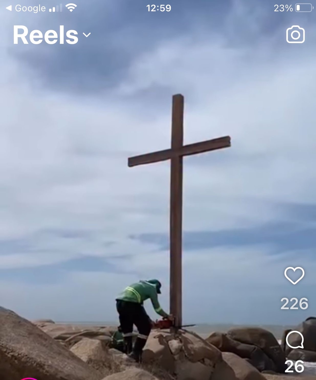 Um sujeito serrando a cruz de mais de 50 anos na Pedra do Sal. Quem mandou?