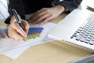 A mão da empresária apontar o gráfico de metas. (Foto: Magnific)
