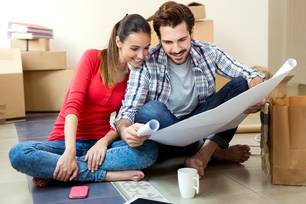 Um jovem casal olhando para os planos de sua nova casa (Foto: Magnific)