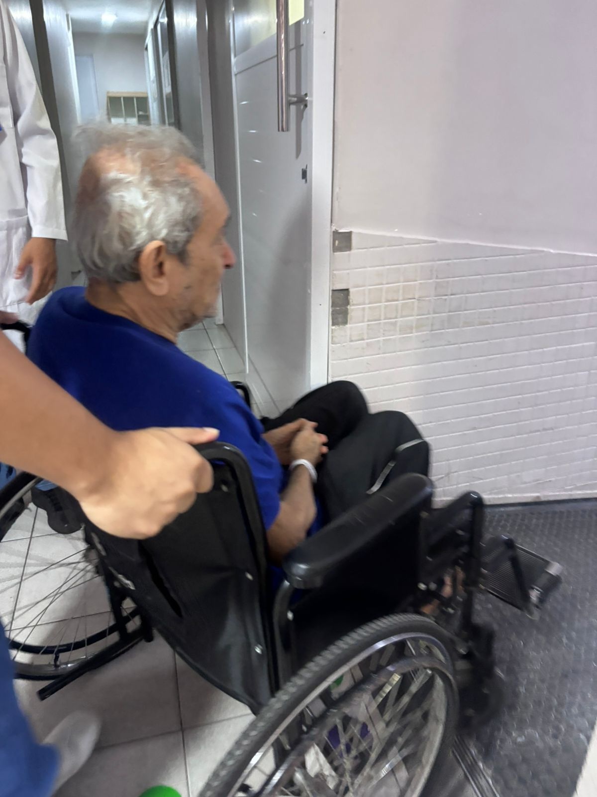 Ari Azevedo, de cadeira, dentro de hospital. O preço da coragem