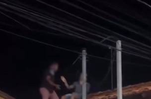 Homem subiu no telhado para tentar fugir das agressões (Foto: Reprodução)