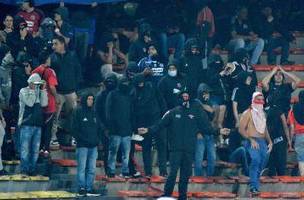 Torcedores encapuzados protestam nas arquibancadas do estádio Atanásio Girardot durante Independiente Medellín x Flamengo (Foto: Daniel Gallo/Vizzor Image/Getty Images)
