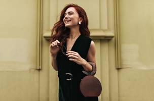 Mulher com bolsa e óculos escuros. (Foto: Pexels)