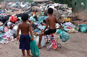 Crianças brincam em área próxima à Baía de Guanabara, no Rio de Janeiro. (Foto: Tânia Rêgo/Agência Brasil)