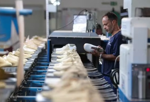 Funcionário trabalha em linha de produção de fábrica de calçados no Brasil.