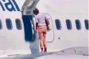 Com calor, mulher abre porta do avião e fica em cima da asa (Foto: -)